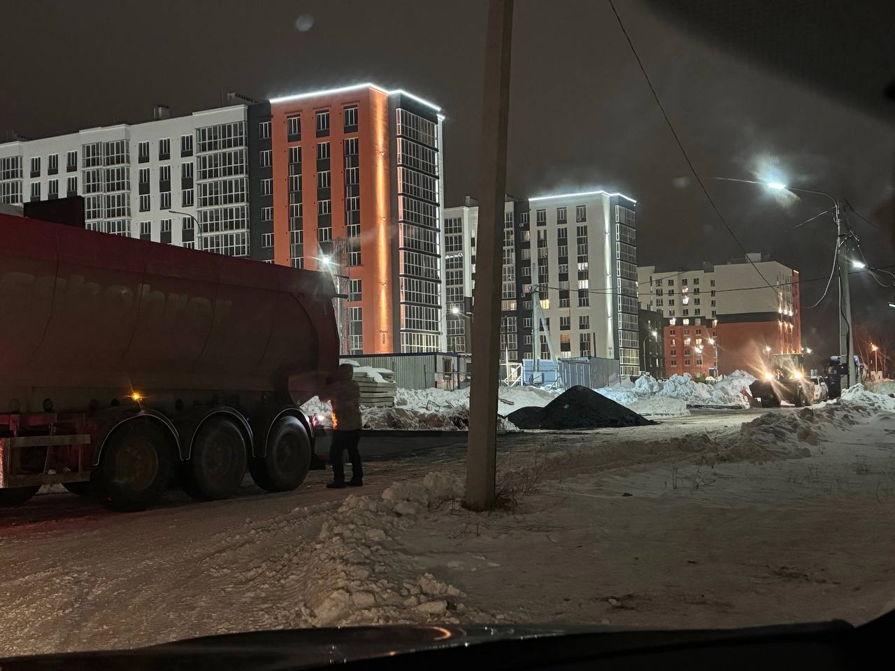 В Рыбном на улице Перспективной укладывают асфальт в снег. Видео